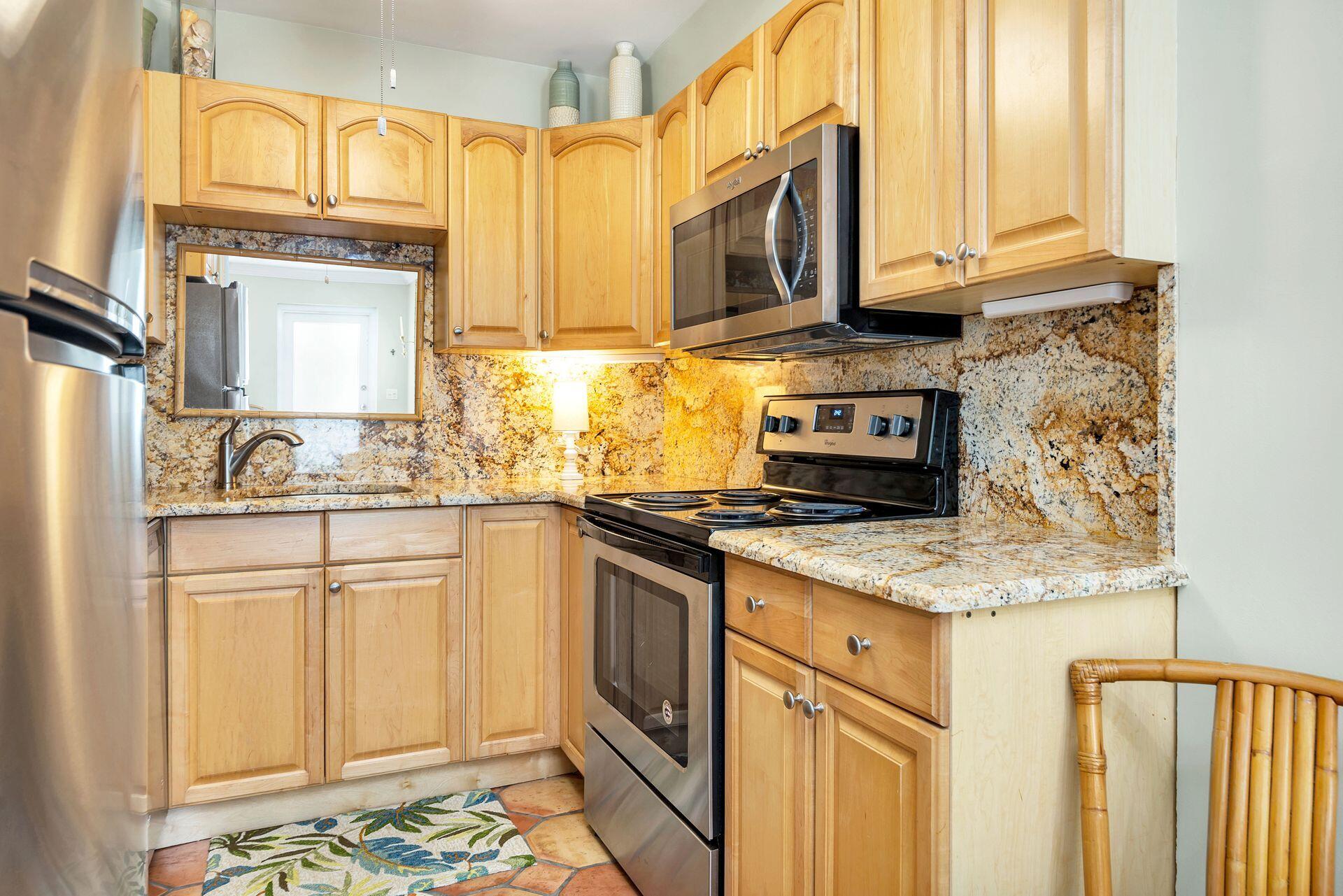 401 Peruvian Avenue, Unit 1050 Palm Beach, FL 33480 - Photo 5 of 17 a kitchen with stainless steel appliances granite countertop a stove a sink and a microwave