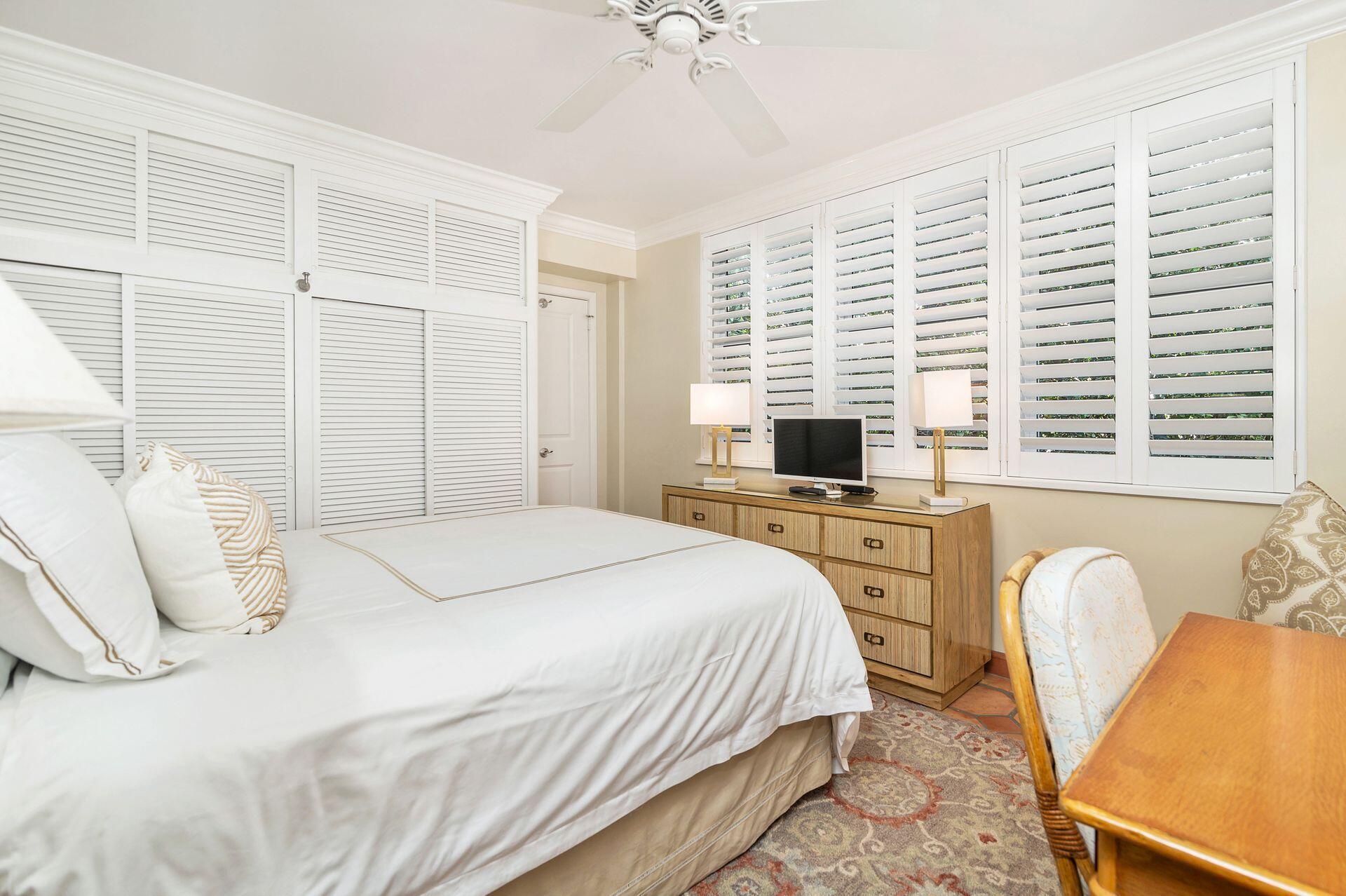 401 Peruvian Avenue, Unit 1050 Palm Beach, FL 33480 - Photo 8 of 17 a bedroom with a bed a chair and a chandelier