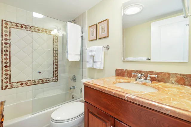 a bathroom with a granite countertop sink toilet and shower