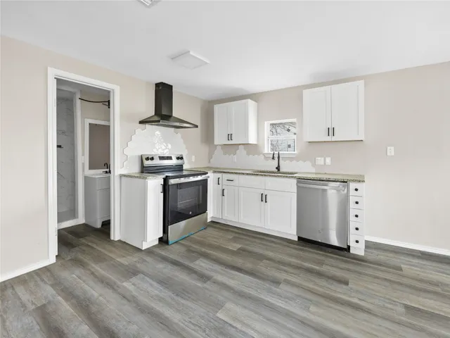 a kitchen with a sink cabinets and wooden floor