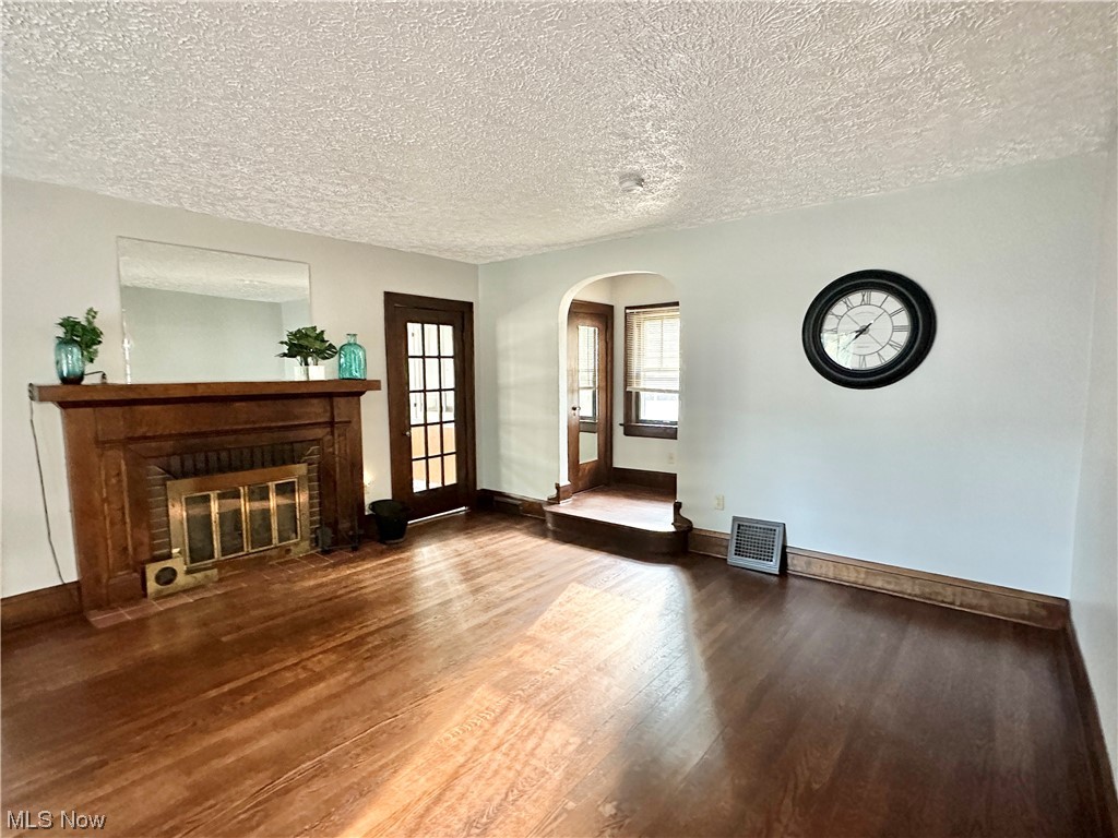 1140 Berwin Street Akron, OH 44310 - Photo 5 of 22 Hardwood floored living room with a textured ceiling and a fireplace