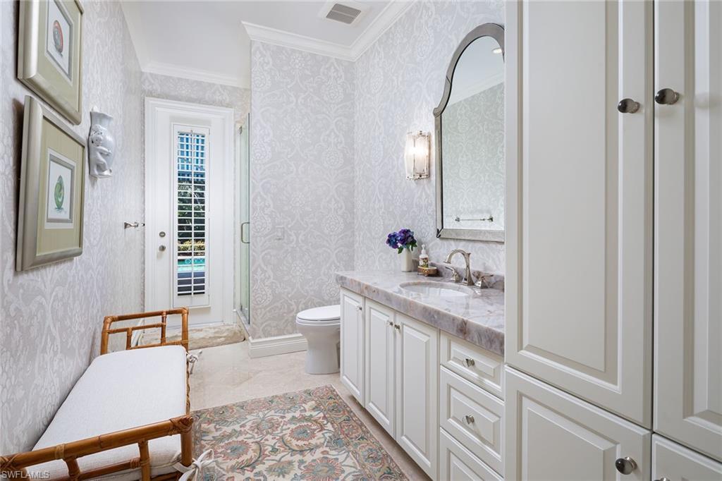 6975 Green Tree Drive Naples, FL 34108 - Photo 20 of 33 Full bathroom with vanity, crown molding, a shower stall, and wallpapered walls