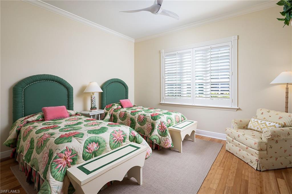 6975 Green Tree Drive Naples, FL 34108 - Photo 22 of 33 Bedroom featuring wood-type flooring, crown molding, and a ceiling fan