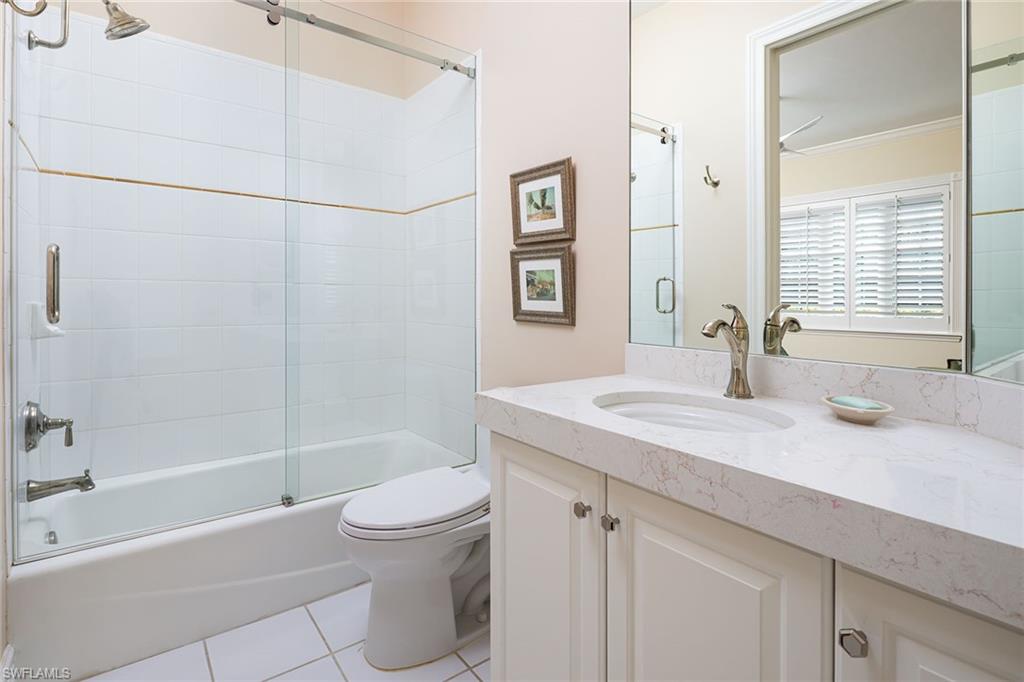 6975 Green Tree Drive Naples, FL 34108 - Photo 25 of 33 Full bath with vanity, shower / bath combination with glass door, light tile patterned floors, and ornamental molding