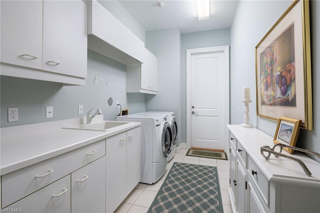 6975 Green Tree Drive Naples, FL 34108 - Photo 26 of 33 Laundry room featuring cabinet space, light tile patterned floors, and separate washer and dryer