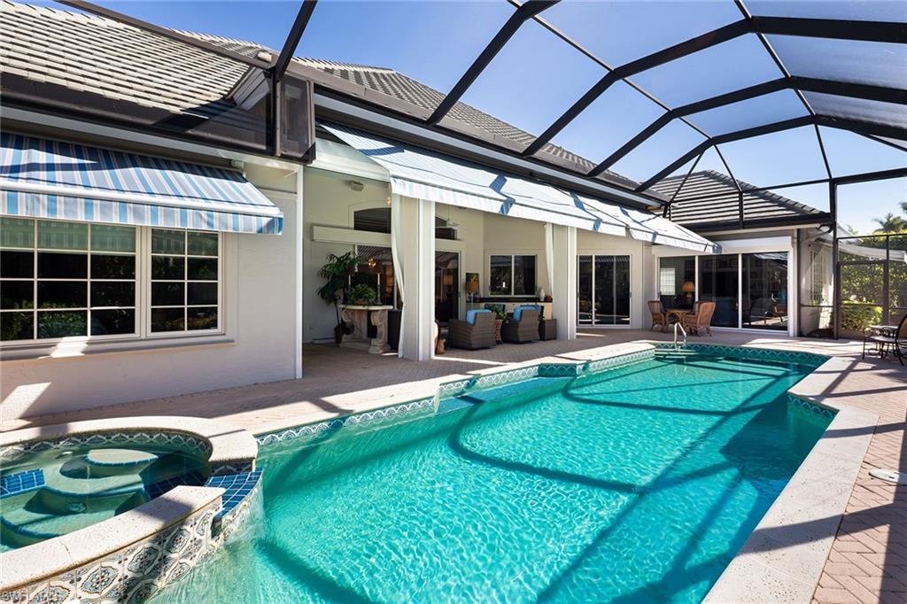 6975 Green Tree Drive Naples, FL 34108 - Photo 30 of 33 View of pool with a sunroom, glass enclosure, a patio, and a pool with connected hot tub