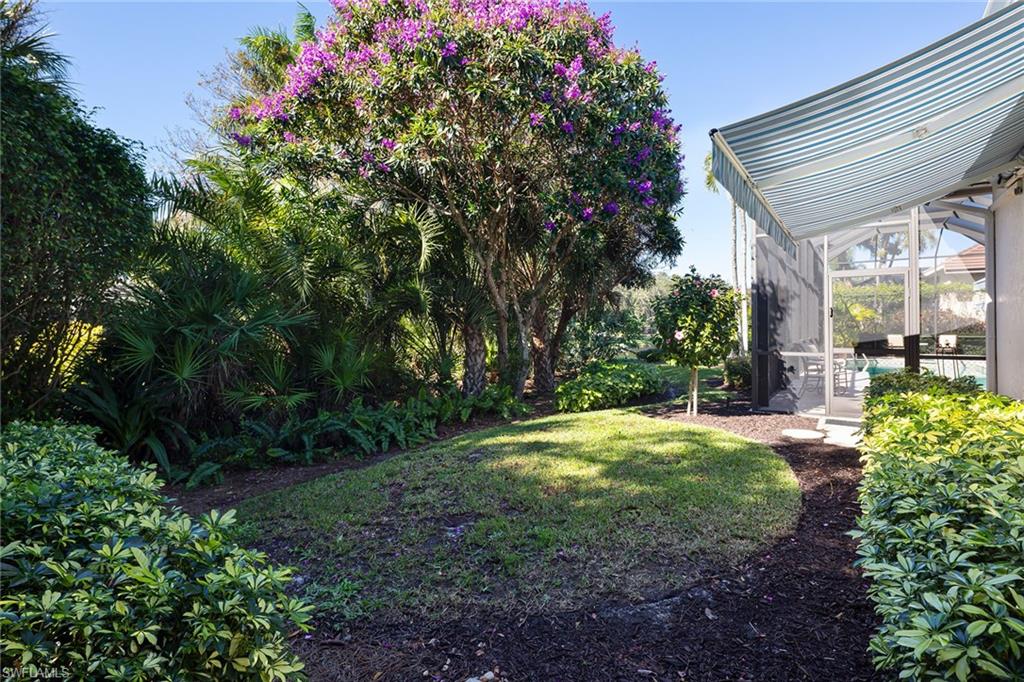 6975 Green Tree Drive Naples, FL 34108 - Photo 31 of 33 View of green lawn with a sunroom and glass enclosure