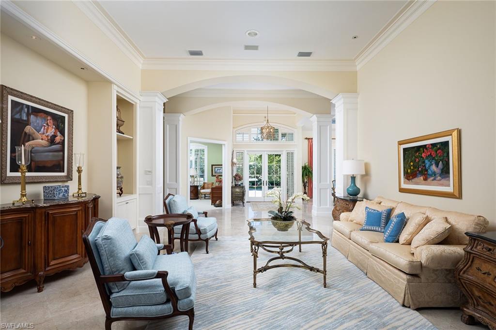 6975 Green Tree Drive Naples, FL 34108 - Photo 4 of 33 Living area with arched walkways, french doors, ornate columns, crown molding, and built in shelves