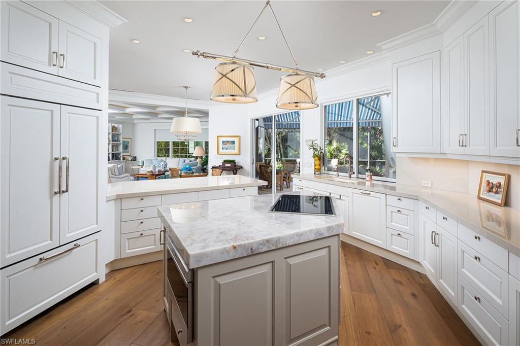 6975 Green Tree Drive Naples, FL 34108 - Photo 6 of 33 Kitchen with a kitchen island, pendant lighting, light stone countertops, recessed lighting, and white cabinetry