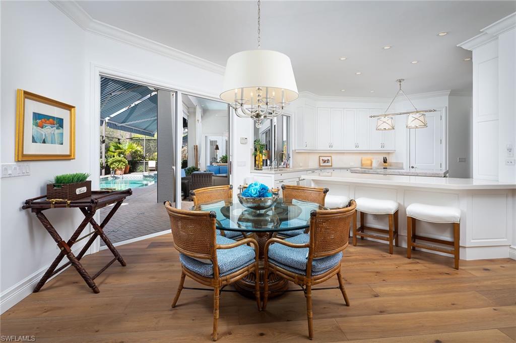 6975 Green Tree Drive Naples, FL 34108 - Photo 8 of 33 Dining room featuring ornamental molding, light wood finished floors, a chandelier, a sunroom, and recessed lighting