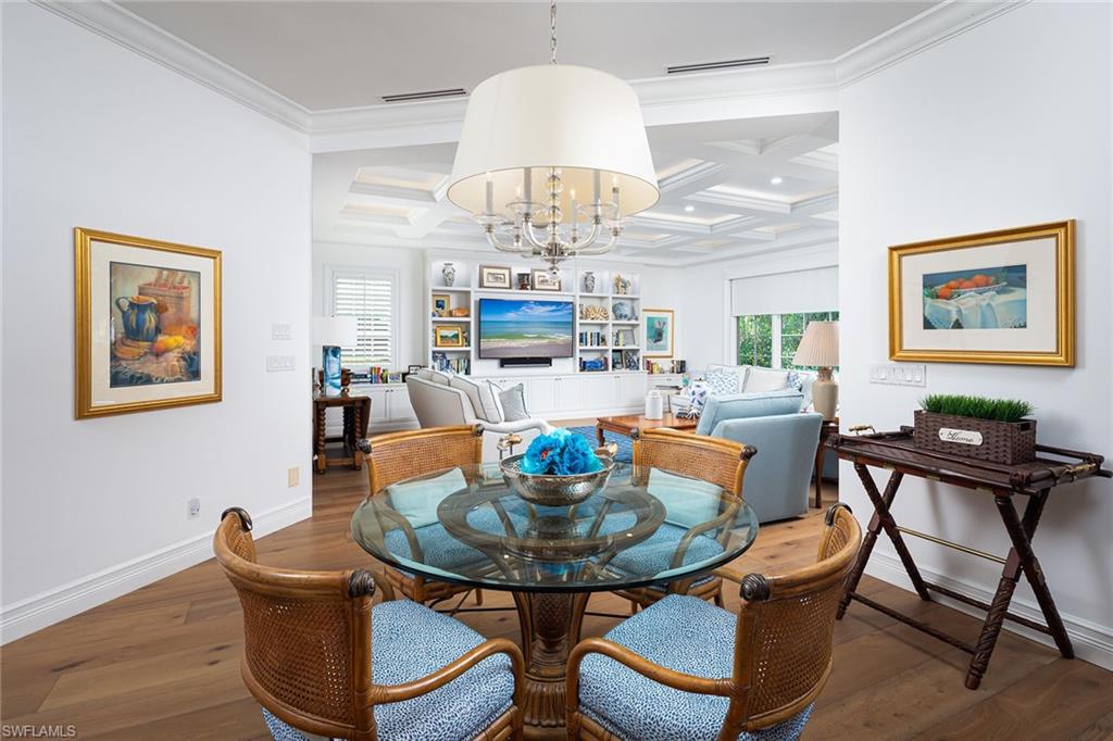 6975 Green Tree Drive Naples, FL 34108 - Photo 9 of 33 Dining area with coffered ceiling, wood-type flooring, a chandelier, beamed ceiling, and ornamental molding