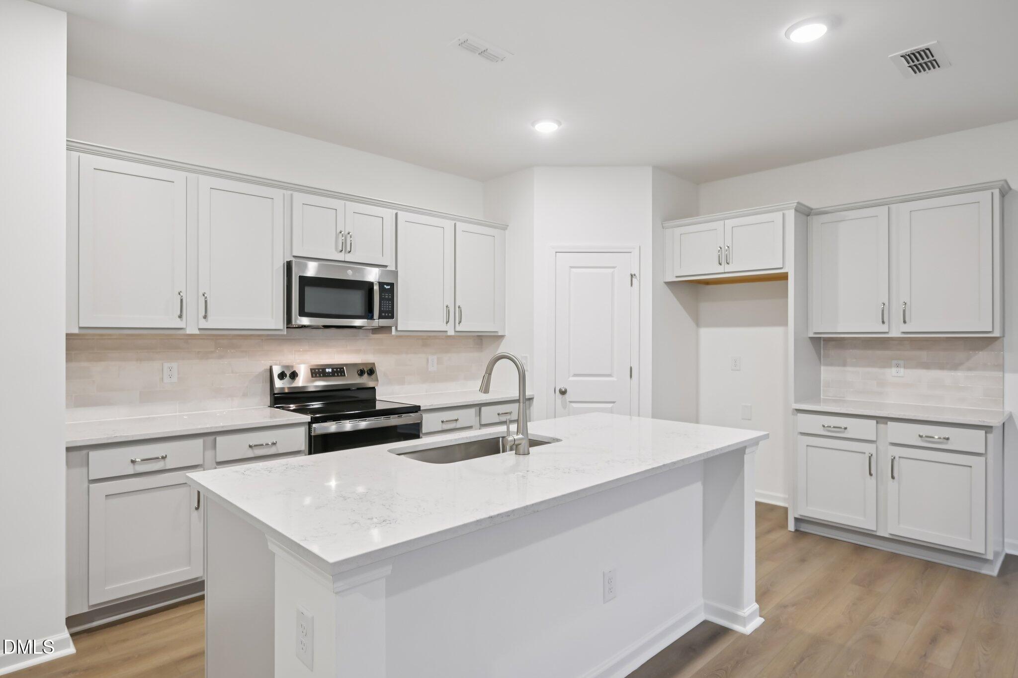 11730 Salers Loop Middlesex, NC 27557 - Photo 12 of 47 a kitchen with sink a microwave and cabinets