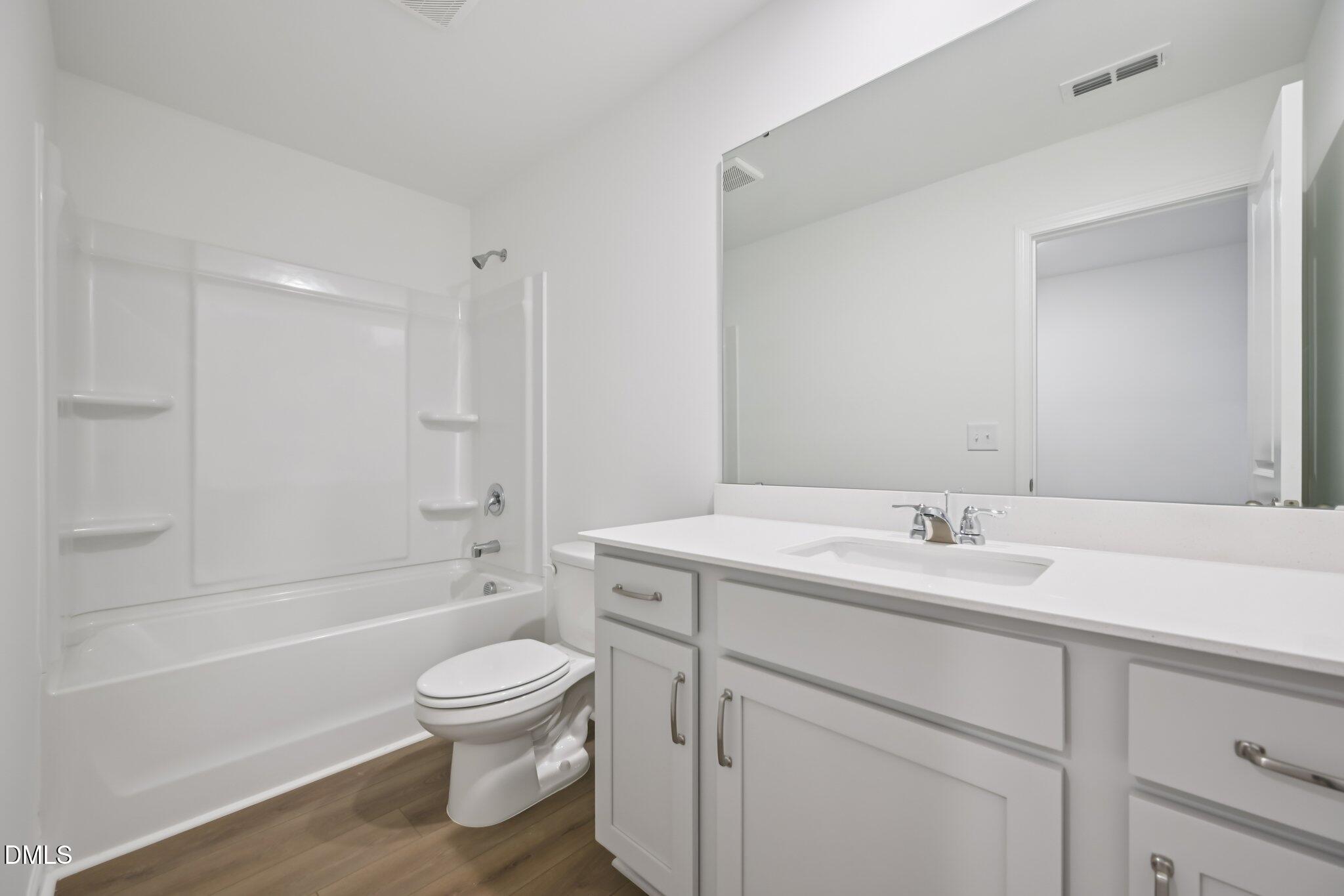 11730 Salers Loop Middlesex, NC 27557 - Photo 29 of 47 a bathroom with a toilet a sink a mirror a bathtub and vanity