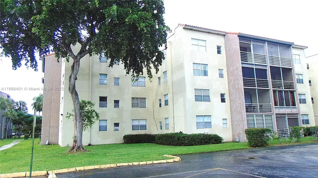 a view of a white building among the palm trees