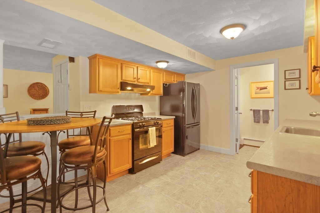 5 Judith E Lane Methuen, MA 01844 - Photo 31 of 38 a kitchen with stainless steel appliances granite countertop a stove top oven a sink a dining table and chairs