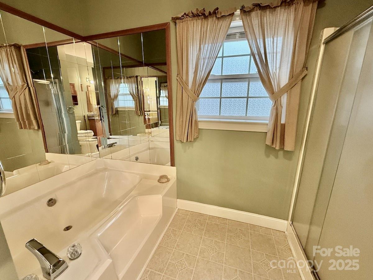1054 Sandy Springs Road Rutherfordton, NC 28139 - Photo 16 of 33 a bathroom with a tub a sink and a window