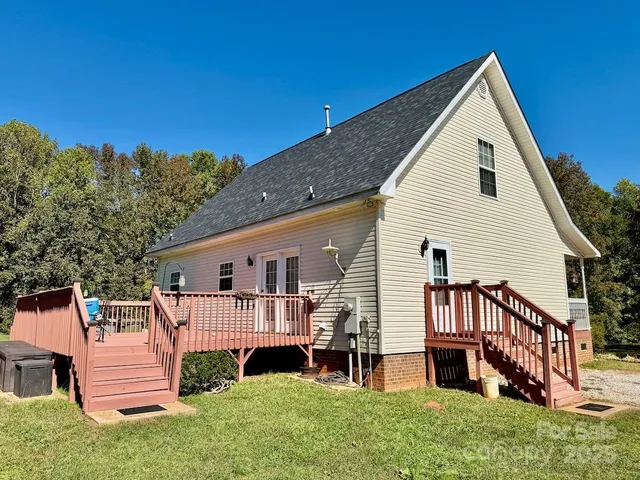 a view of backyard with deck and outdoor seating