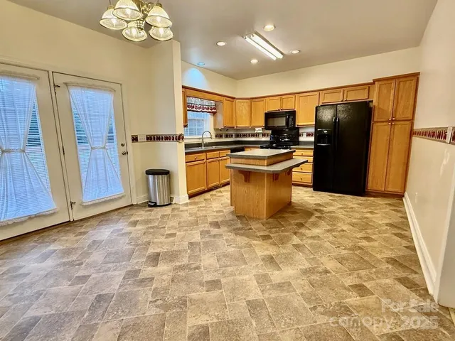 a kitchen with stainless steel appliances granite countertop a refrigerator a sink a stove a microwave and island