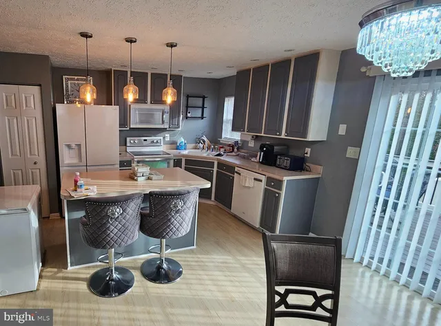 a kitchen with granite countertop a sink appliances and cabinets