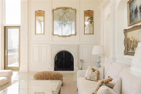 a living room with fireplace furniture and a large window