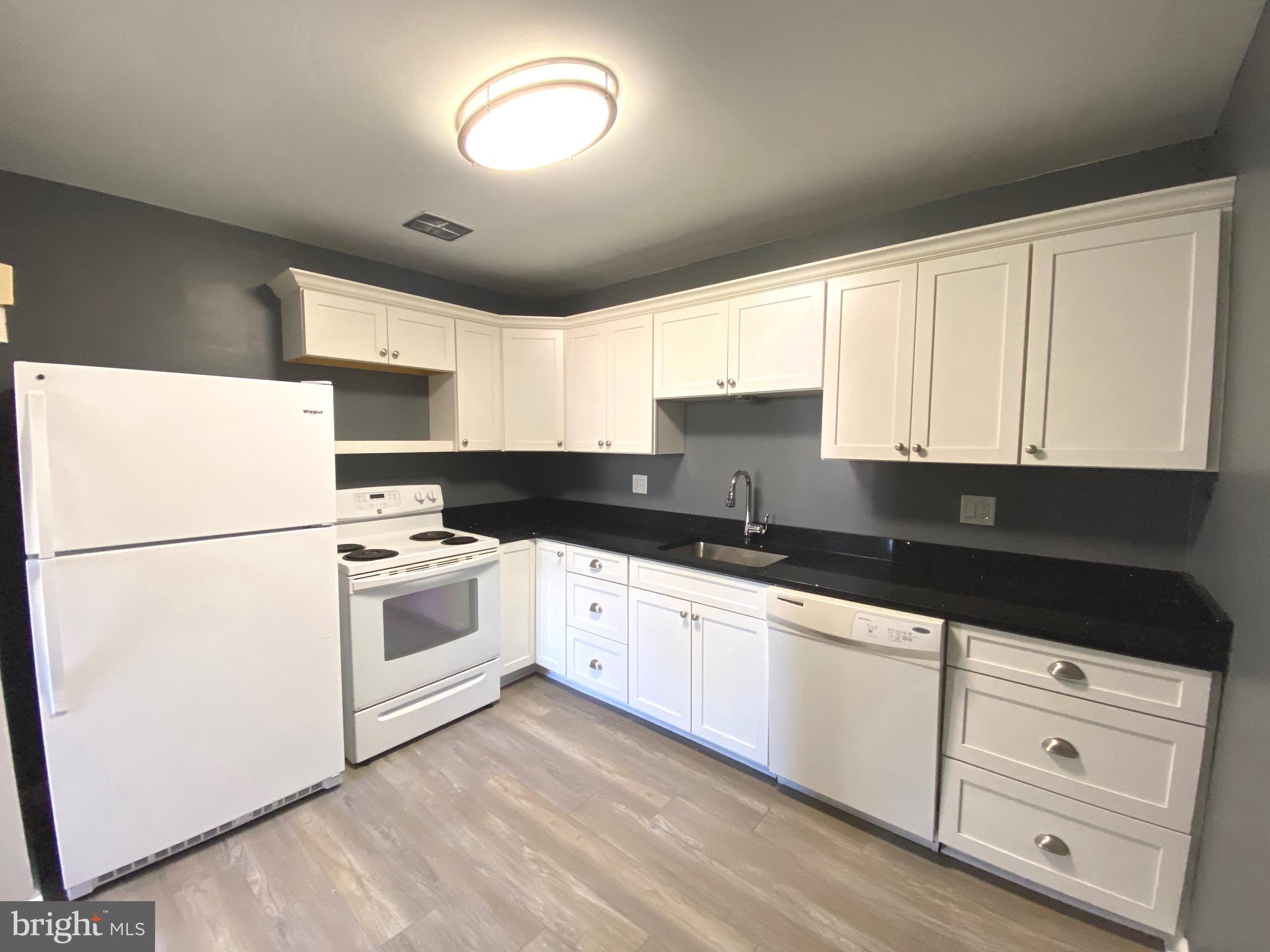4000 Gypsy Lane, Unit 520 Philadelphia, PA 19129 - Photo 9 of 18 a kitchen with granite countertop white cabinets and white appliances
