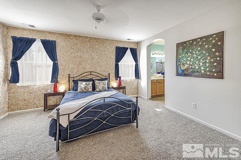 10442 Rockport Lane Reno, NV 89521 - Photo 11 of 17 a bedroom with a bed a mirror and a window