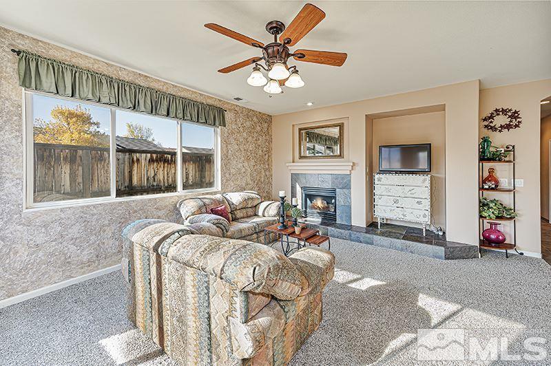 10442 Rockport Lane Reno, NV 89521 - Photo 6 of 17 a living room with furniture a chandelier and a fireplace