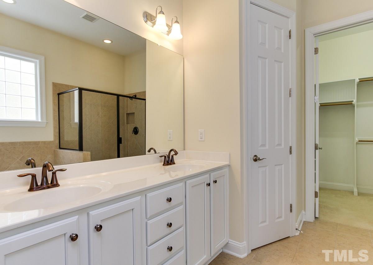 932 Chapanoke Road Raleigh, NC 27603 - Photo 15 of 25 a bathroom with a double vanity sink and a mirror