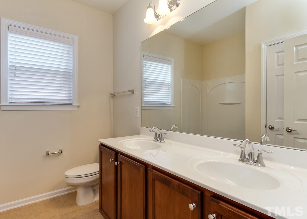 932 Chapanoke Road Raleigh, NC 27603 - Photo 23 of 25 a bathroom with a granite countertop sink toilet and a mirror