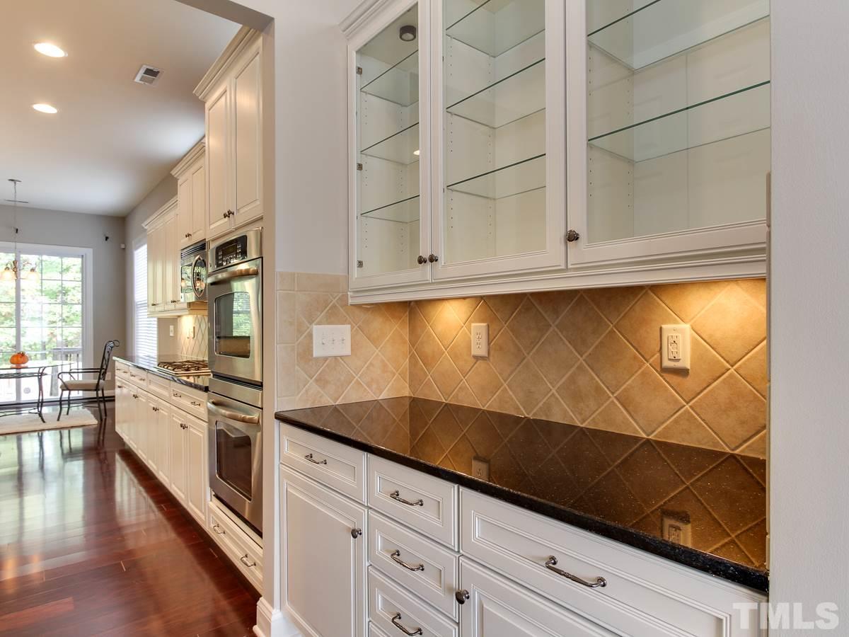932 Chapanoke Road Raleigh, NC 27603 - Photo 5 of 25 a kitchen with granite countertop white cabinets and stainless steel appliances