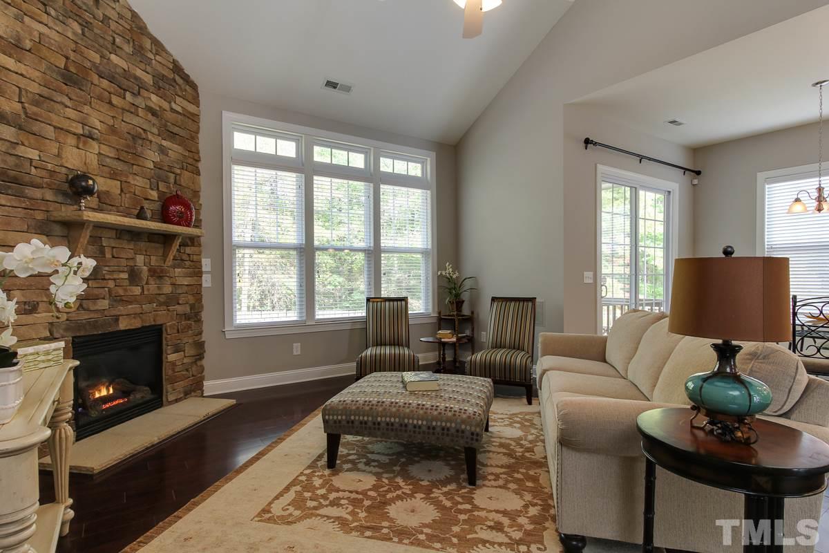 932 Chapanoke Road Raleigh, NC 27603 - Photo 9 of 25 a living room with furniture a fireplace and a floor to ceiling window
