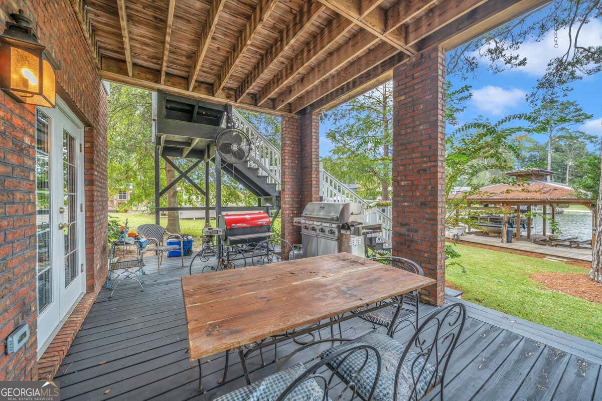 696 Cork Ferry Road Cordele, GA 31015 - Photo 61 of 79 a view of a patio with table and chairs potted plants with wooden floor and fence