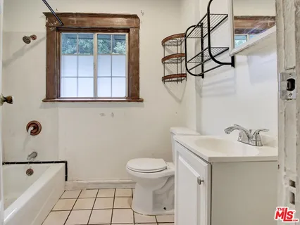 a view of an empty room with window chandelier fan