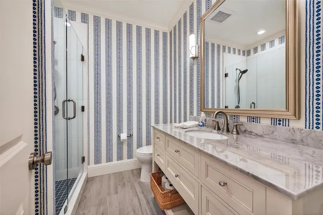a bathroom with a granite countertop sink a mirror a vanity and a shower