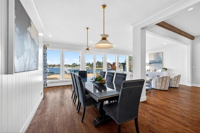 a dining room with stainless steel appliances kitchen island granite countertop a table chairs and a living room