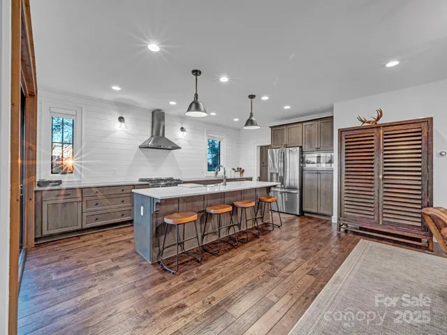 a kitchen with stainless steel appliances granite countertop a sink cabinets and wooden floor