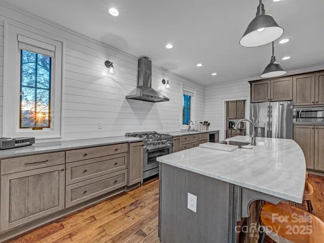 a kitchen with stainless steel appliances granite countertop a sink stove and refrigerator