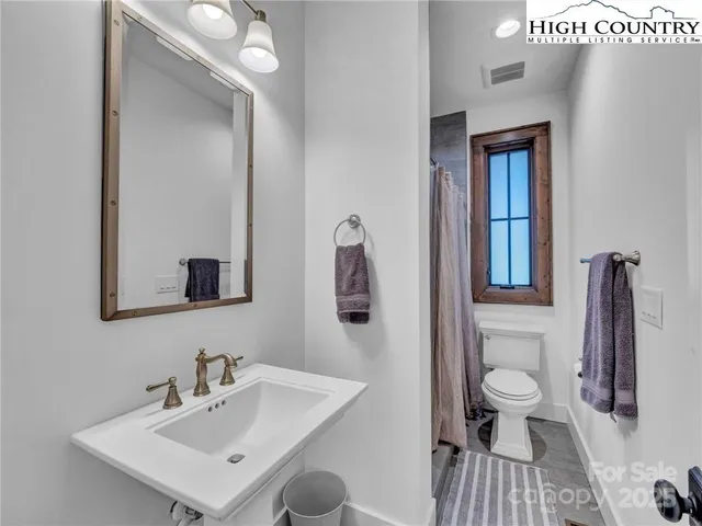 a bathroom with a sink a toilet and a mirror