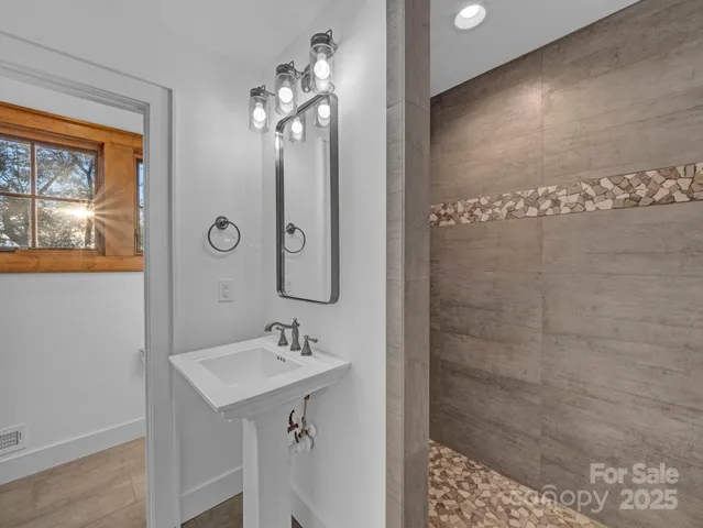 a bathroom with a sink a mirror and a shower