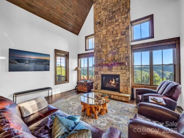 a living room with furniture a fireplace and a floor to ceiling window