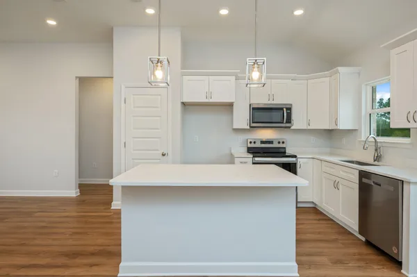 a kitchen with kitchen island a sink stainless steel appliances and cabinets