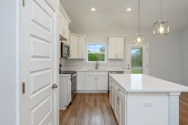 a kitchen with white cabinets and white appliances