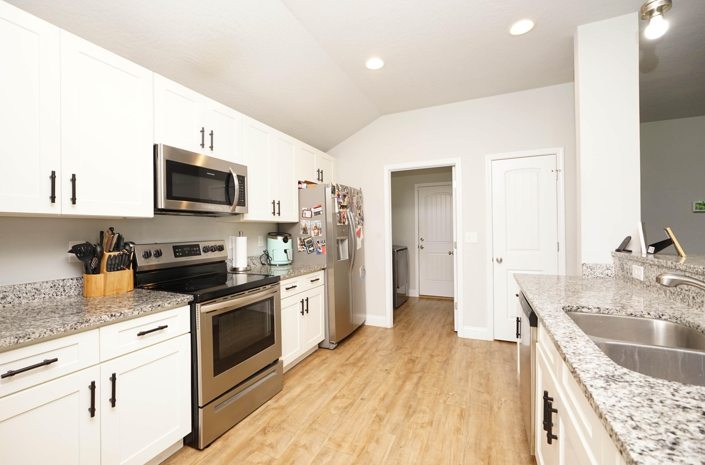 415 Scooter Cove Crestview, FL 32539 - Photo 6 of 45 a kitchen with granite countertop a sink wooden floor and stainless steel appliances