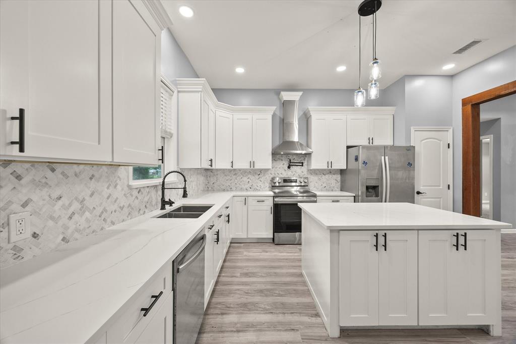 9469 Lakeland Loop Quinlan, TX 75474 - Photo 12 of 31 a kitchen with white cabinets sink and stainless steel appliances