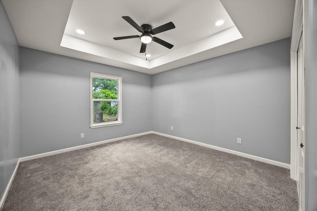 9469 Lakeland Loop Quinlan, TX 75474 - Photo 23 of 31 an empty room with ceiling fan and windows