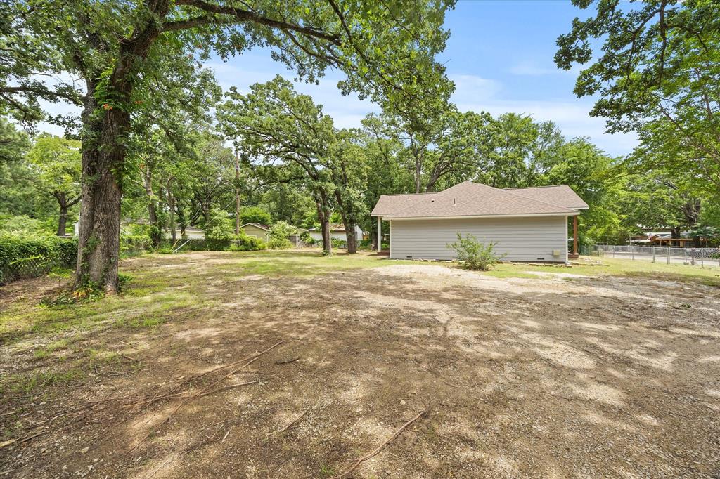9469 Lakeland Loop Quinlan, TX 75474 - Photo 25 of 31 a front view of a house with a garden and trees