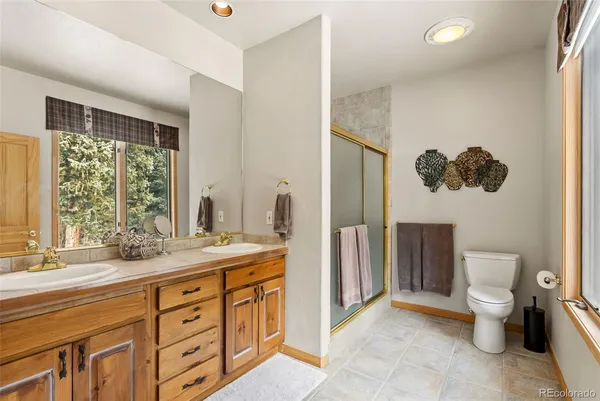 a spacious bathroom with a double vanity sink toilet and a tub