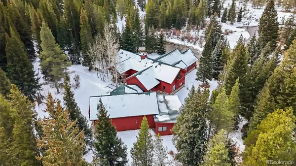 an aerial view of a house with swimming pool and red chairs