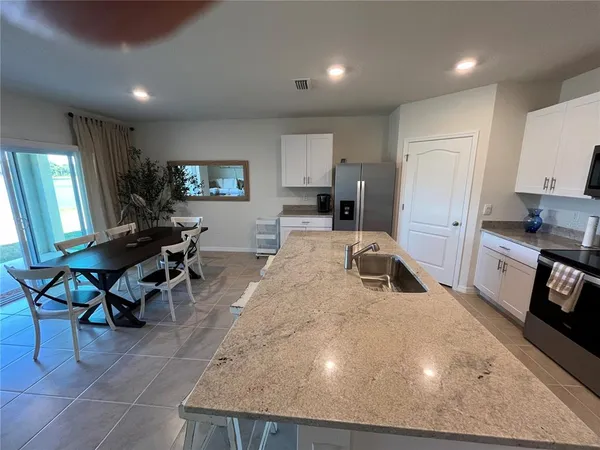 a kitchen with sink a microwave and cabinets