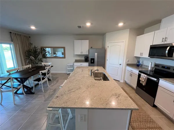 a kitchen with stainless steel appliances granite countertop a sink a stove and a refrigerator